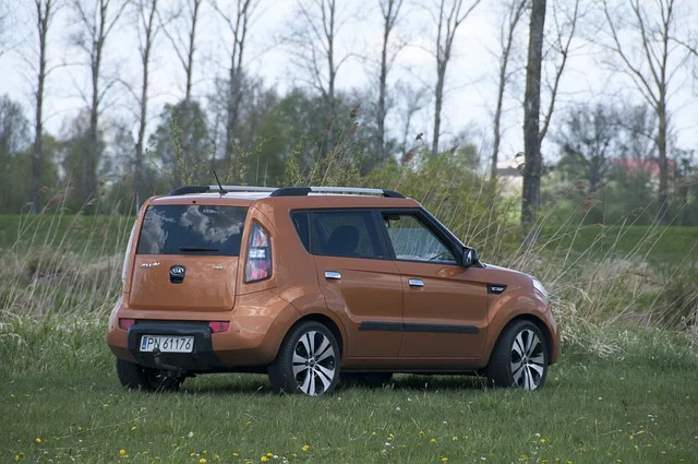 Orange Kia Soul parked in a field