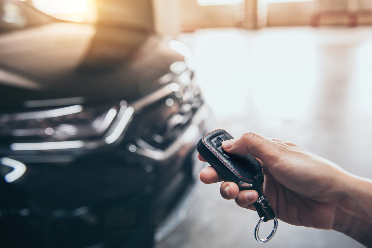 Photo of hand unlocking car with key fob